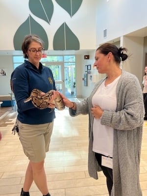 Zoo employee shows program attendees a python